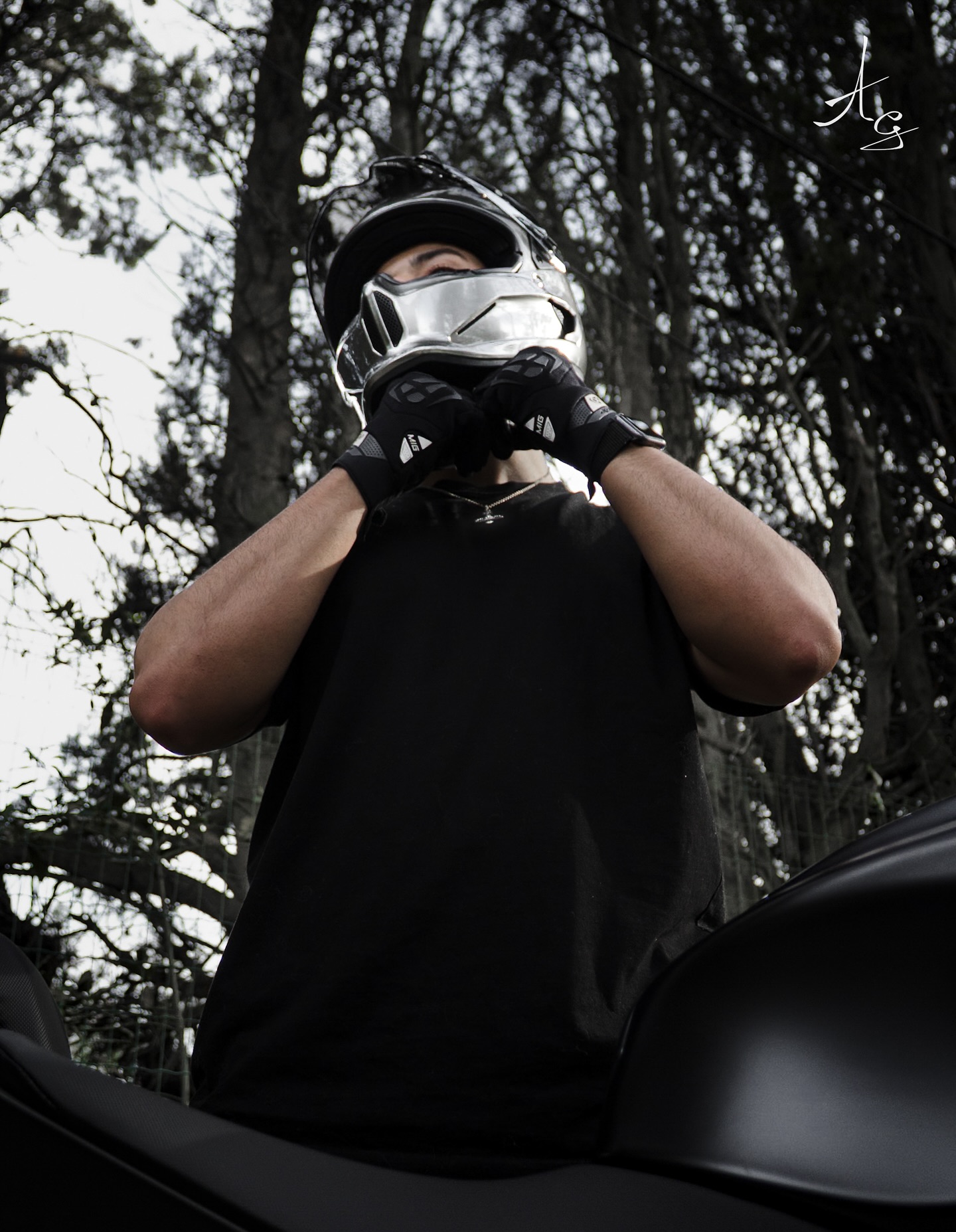 Portrait d'un motard ajustant son casque en forêt – shooting portrait